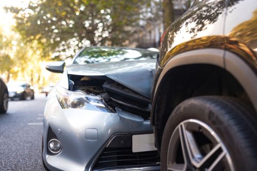 Close-up of two cars damaged in road traffic accident, no people.